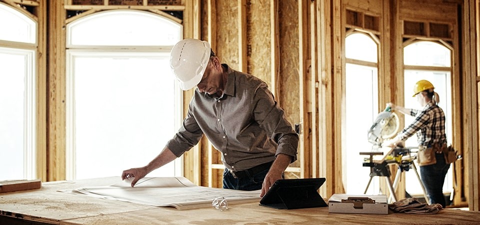 Builder laying out blueprints