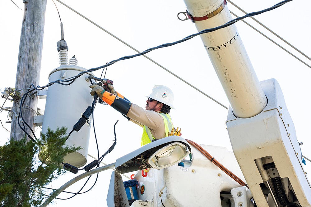 Line worker fixing transmission pole