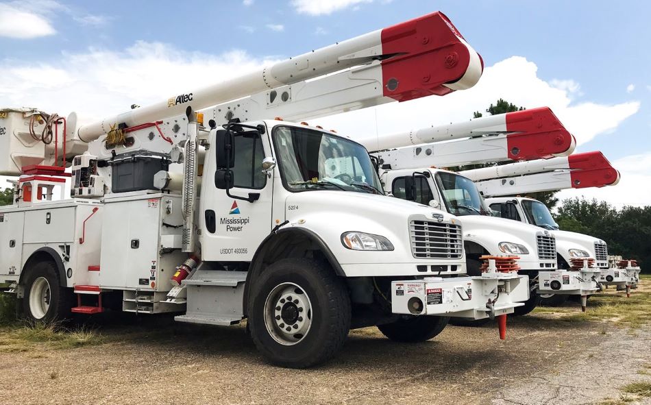 Mississippi Power bucket trucks lined up at a staging area.