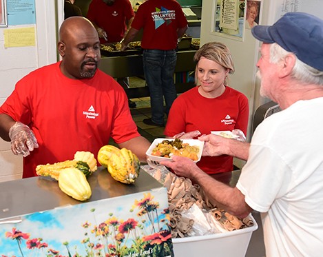 Mississippi Power volunteers giving vegtables to a man in need