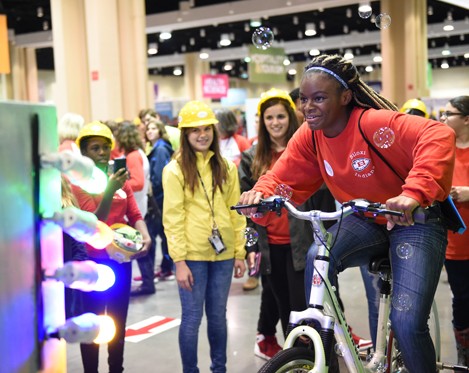 Girl riding bike as other kids watch