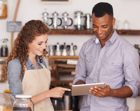 A man and woman looking at a tablet