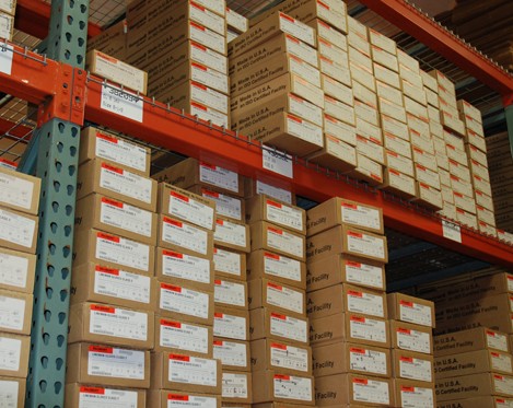 Boxes of PPE Tested products stacked on warehouse shelf