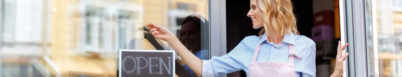 Women standing in doorway with Open sign