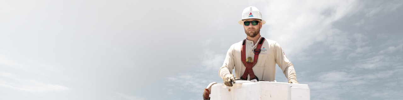 photo of lineman in bucket with strom clouds