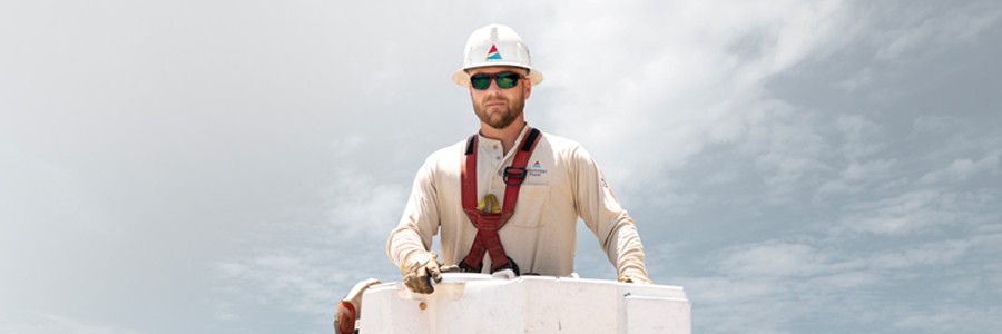 photo of lineman in bucket with strom clouds
