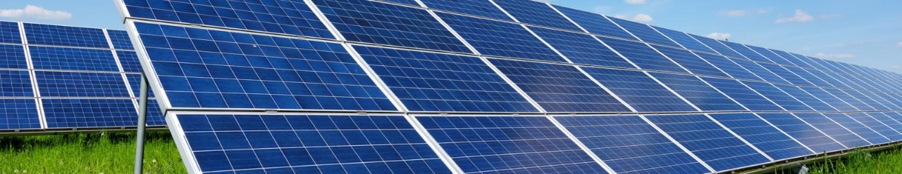 Rows of solar panels in a green field