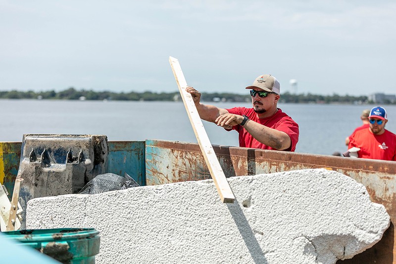 Two men cleaning a river shoreline