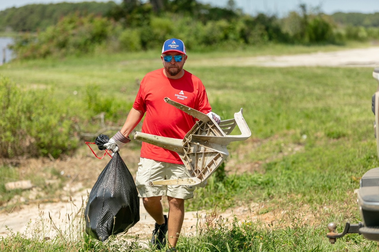 Volunteer picking up trash in a marsh