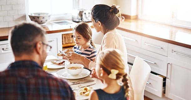 Family sitting around a table eating breakfast 