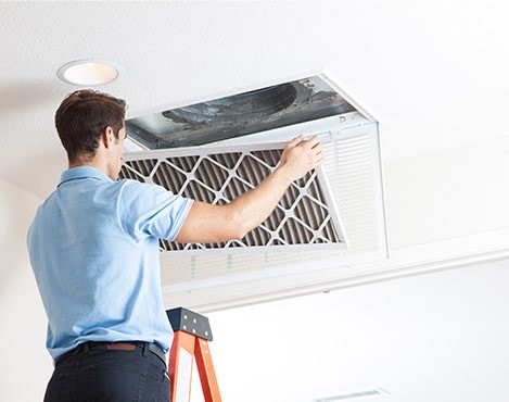 man replacing home ac filter