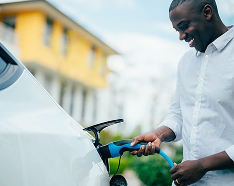 man charging electric vehicle